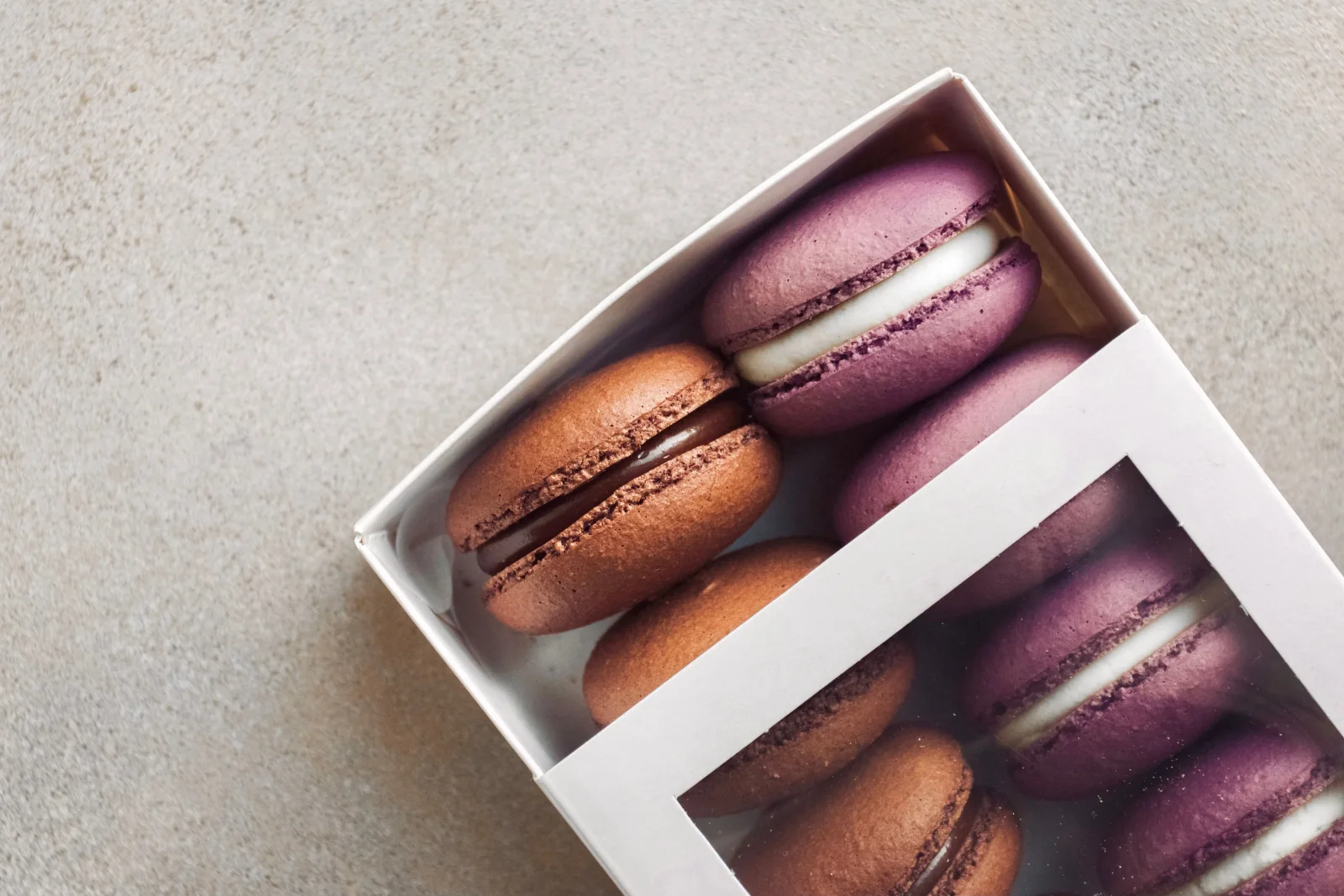 Pastel macarons arranged in an open gift box