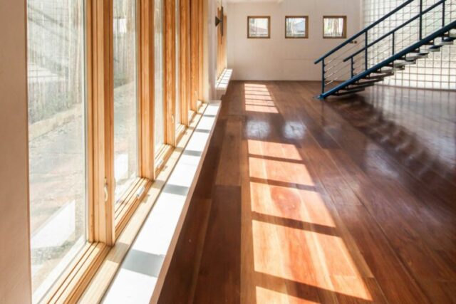 Brown wooden parquet floor with glass windows, photographed by Miguel Luis