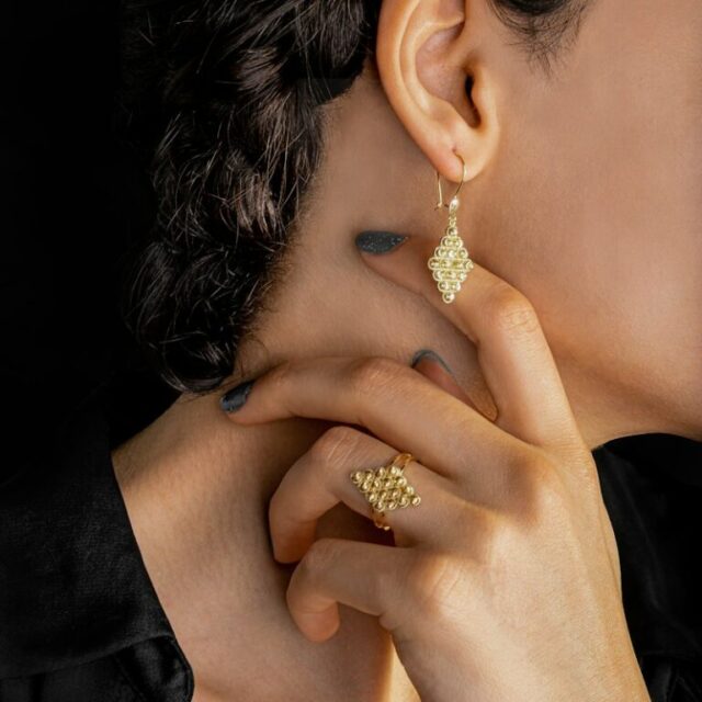 A drop earring and a ring, close