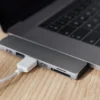 USB-C multiport adapter connected to a laptop on a wooden desk.