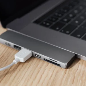 USB-C multiport adapter connected to a laptop on a wooden desk.