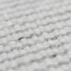 Close-up view of a grey handmade woolen rug texture showing detailed weave.