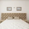Elegant beige bedroom featuring a quilted headboard, plush pillows, and minimalistic decor.
