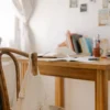 Rustic wooden desk in cozy home office with books and net bag. Ideal for studying or working.